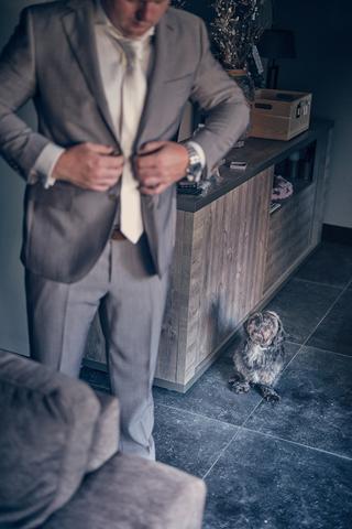 Bruidegom Jordy in beige pak stropdas rechtstrekkend, hond aanwezig bij ceremonie Wantij Paviljoen Dortrecht, trouwreportage