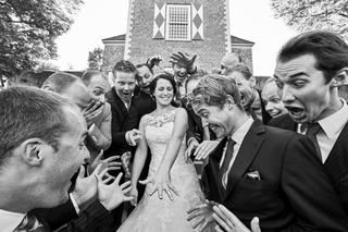 Bruid omringd door vrolijke gasten bij kerk, destination wedding fotografie met veel plezier — Trouwshoot Stefan Segers