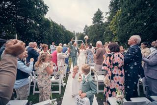 Bruidspaar Dennis en Kim bij hun ceremonie op Kasteel De Hooge Vuursche, omgeven door applaudisserende gasten en drijvende ze