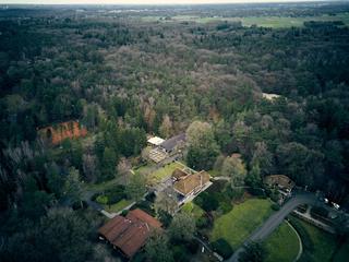 Luchtfoto van het Fletcher Hotel Wipselberg te Beekbergen tijdens de bruiloft van Jeroen en Martijn, omgeven door bos en land