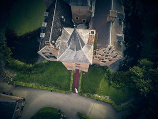 Bruidspaar Renee en Fabian lopen over het rode looppad naar Kasteel Wijnenburg in Echteld - luchtfoto - Trouwshoot Stefan Seg