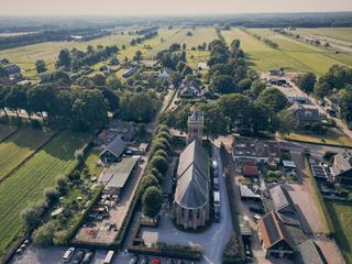 Luchtfoto bruidspaar Bram en Elles bij Het Dikke Torentje, trouwceremonie in pittoreske dorpsomgeving, trouwreportage - Trouw