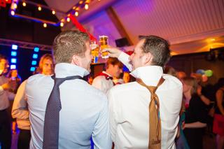 Bruidegoms Sander en Linma toasten op trouwfeest met kleurrijke verlichting, bruiloft Utrecht - Trouwshoot Stefan Segers