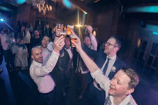 Bruidegoms Jeroen en Martijn toasten uitgelaten met gasten op trouwfeest Fletcher Hotel Wipselberg - Trouwshoot Stefan Segers