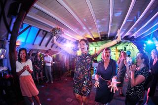 Bruidspaar Menno en Esther dansen uitgelaten met gasten onder kleurrijke lichtshow op Hoeve Sparredam - Trouwshoot Stefan Seg