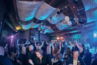 Bruidsgasten dansen op trouwreceptie met blauwe neonverlichting, feestelijke trouwreportage - Trouwshoot Stefan Segers