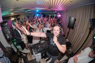 DJ Milou en Theron draaien op trouwfeest in Kamerik, feestende gasten dansen onder kleurrijke verlichting - Trouwshoot Stefan