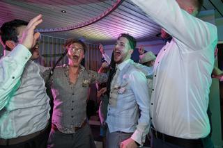 Bruidspaar Milou en Theron feest op trouwfeest in Kamerik Woerden, gasten dansen onder paarse lichten, joyeuze trouwreportage