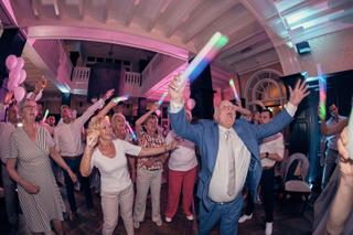 Bruidsgasten dansen feestelijk met glow sticks op trouwreceptie Kasteel De Hooge Vuursche, huwelijk Dennis en Kim - Trouwshoo