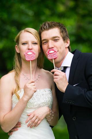 Bruidspaar Feike en Martijn spelen met kiss me photobooth props op Kasteel Woerden - Trouwshoot Stefan Segers