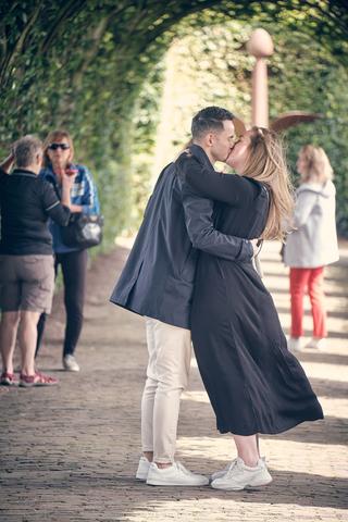 Wai Ho en Marinka kussen romantisch onder de groene bomengang bij Muiderslot kasteel - Trouwshoot Stefan Segers
