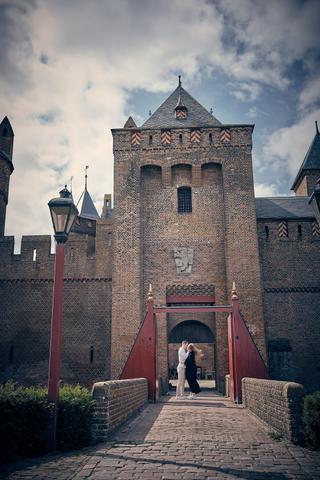 Bruidspaar Marinka en Wai Ho kussen bij poort Muiderslot kasteel, romantische loveshoot trouwreportage - Trouwshoot Stefan Se
