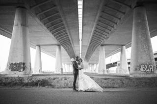 Bruidspaar Ellen en Jeroen kussen onder betonnen viaduct in Vianen, modern trouwfoto zwart-wit - Trouwshoot Stefan Segers
