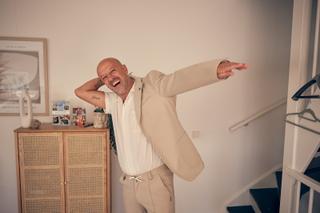 Bruidegom Chris in beige pak springt jubelend in de lucht, vrolijke trouwreportage IJsselstein - Trouwshoot Stefan Segers