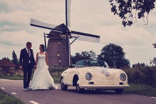 Bruidspaar Angela en Auke hand in hand bij Nederlandse windmolen Hazerswoude-Dorp, vintage Porsche trouwreportage - Trouwshoo