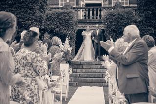Bruidspaar Dennis en Kim verlaat trouwceremonie onder Kasteel De Hooge Vuursche, gasten applaudisseren, romantische trouwrepo