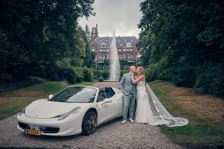 Bruidspaar Dennis en Kim kussen bij witte Ferrari voor Kasteel De Hooge Vuursche, fontein en ivyomlijste lanen op achtergrond
