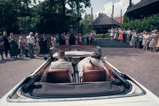 Bruidspaar in klassieke cabriolet voor gasten op Het Wapen van Zoetermeer - Trouwshoot Stefan Segers