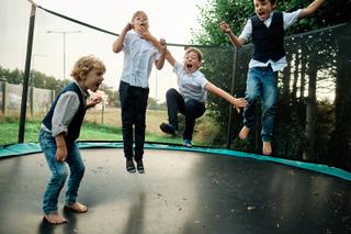 Kinderen Helen, Burt, Robert en Daniel springen op trampoline, bruiloftskindergame Hoeve Kromwijk - Trouwshoot Stefan Segers