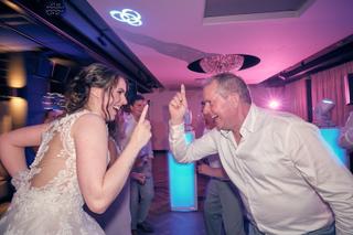 Bruid Wendy danst uitgelaten met gast op trouwfeest Het Wapen van Zoetermeer, neonverlichting, trouwreportage - Trouwshoot St