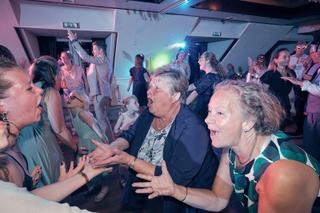 Bruidspaar Herre en Ingeborg dansen feestelijk met gasten op trouwfeest Louwman Museum Pijnacker Zoetermeer, trouwreportage -