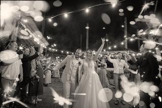 Bruidspaar Robin en Wendy viert huwelijk met sparklers en gasten onder lichtslinger, feestelijke avondreportage Het Wapen van