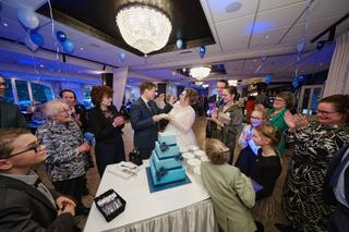 Bruidspaar Christa en Gerco snijden taart bij trouwreceptie Wapen van Zoetermeer, gasten kijken toe - Trouwshoot Stefan Seger