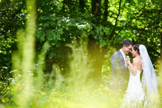 Bruidspaar Sanne en Patrick hand in hand in bloemenweide Westerpark Zoetermeer, romantische trouwreportage - Trouwshoot Stefa