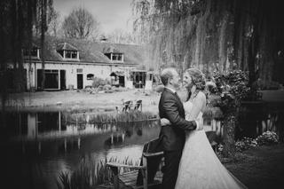 Mark en Kelly aan de waterpartij van boerderij Land van Belofte, innig moment tussen wilgen - Trouwshoot Stefan Segers