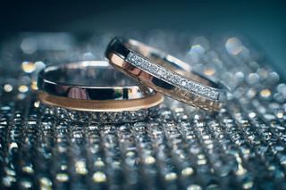 Gouden en zilveren trouwringen met diamanten op glitterende ondergrond, bruidsfotografie Zoetermeer Westerpark - Trouwshoot S
