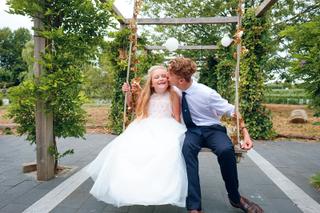 Bruidspaar op schommel onder pergola met groene klimop, trouwreportage Westerpark Zoetermeer - Trouwshoot Stefan Segers