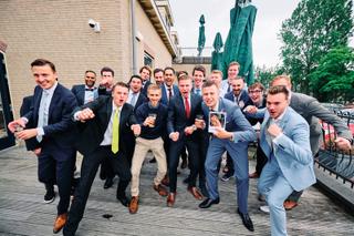 Bruidegom Daniel en groomsmen springen vrolijk op terras Wapen van Zoetermeer - Trouwshoot Stefan Segers