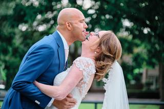 Bruidspaar Chantal en Ian kussen speels in groene tuin - Trouwshoot Stefan Segers