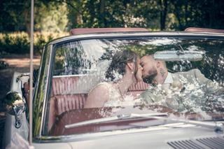 Bruidspaar Robin en Wendy kussen in klassieke cabriolet bij Het Wapen van Zoetermeer, trouwreportage Westerpark - Trouwshoot