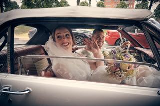 Bruidspaar Robin en Wendy zwaaien uit vintage auto na ceremonie, trouwreportage Het Wapen van Zoetermeer Ypenburg - Trouwshoo
