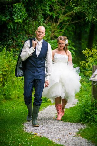 Bruidspaar Mathijs en Marijn loopt hand in hand door groene tuin, trouwreportage Hoeve Kromwijk Zoetermeer - Trouwshoot Stefa